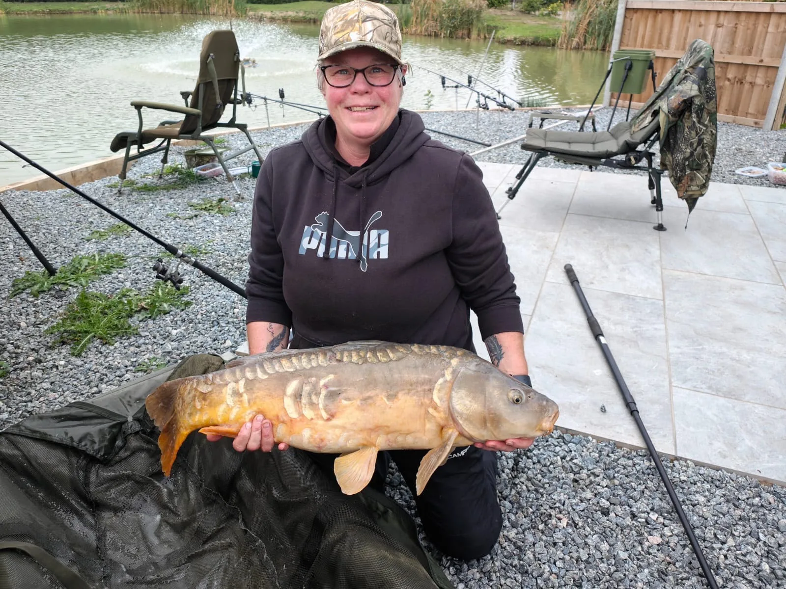 A guest holding a large carp caught at Manea Fisheries